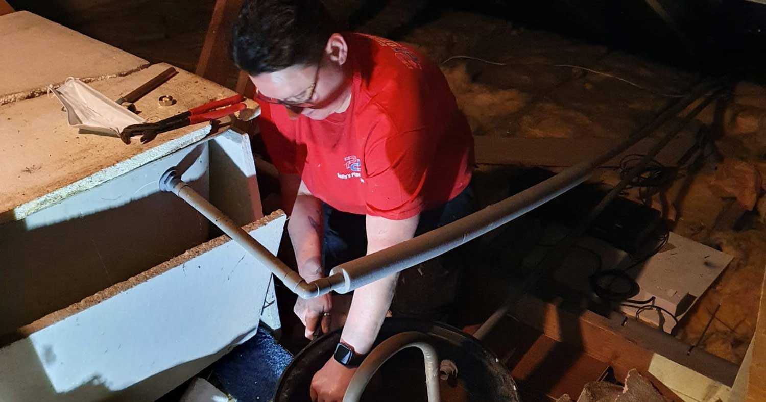 Sally King working in loft space - cold water tank