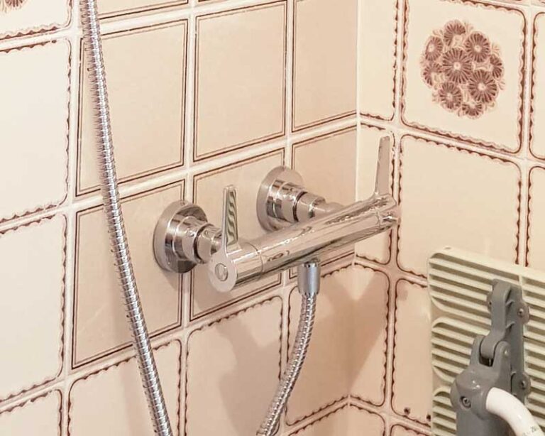 Replace concealed shower valve with exposed shower valve with a bit of tile work
